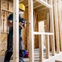 Handwerker bohrt mit Bosch Expert Flachfräsbohrer ein Loch in eine Holzwand.