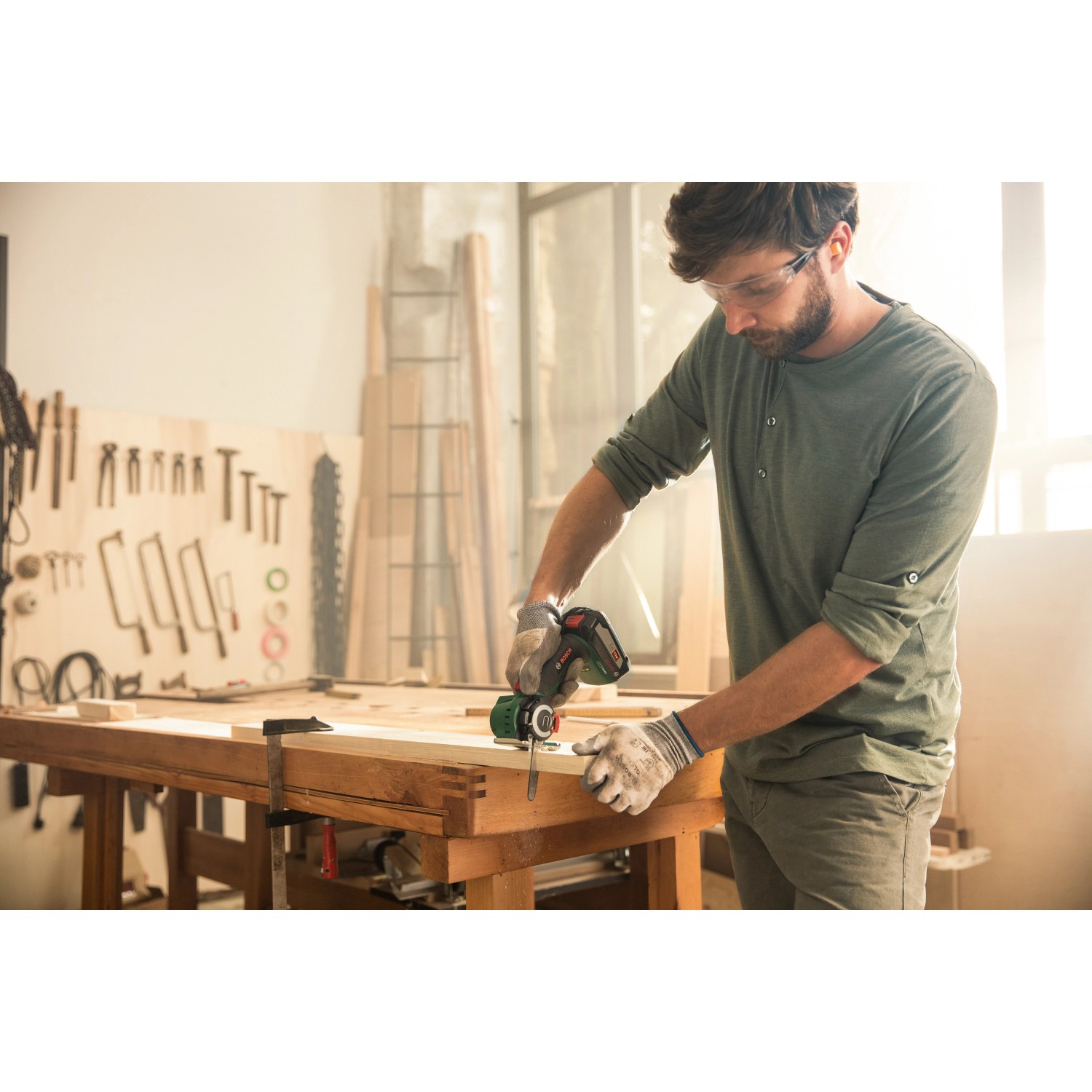 Mann sägt Holz mit Bosch Akku-Säge NanoBlade AdvancedCut 18. Stichsäge mit Akku im Einsatz.