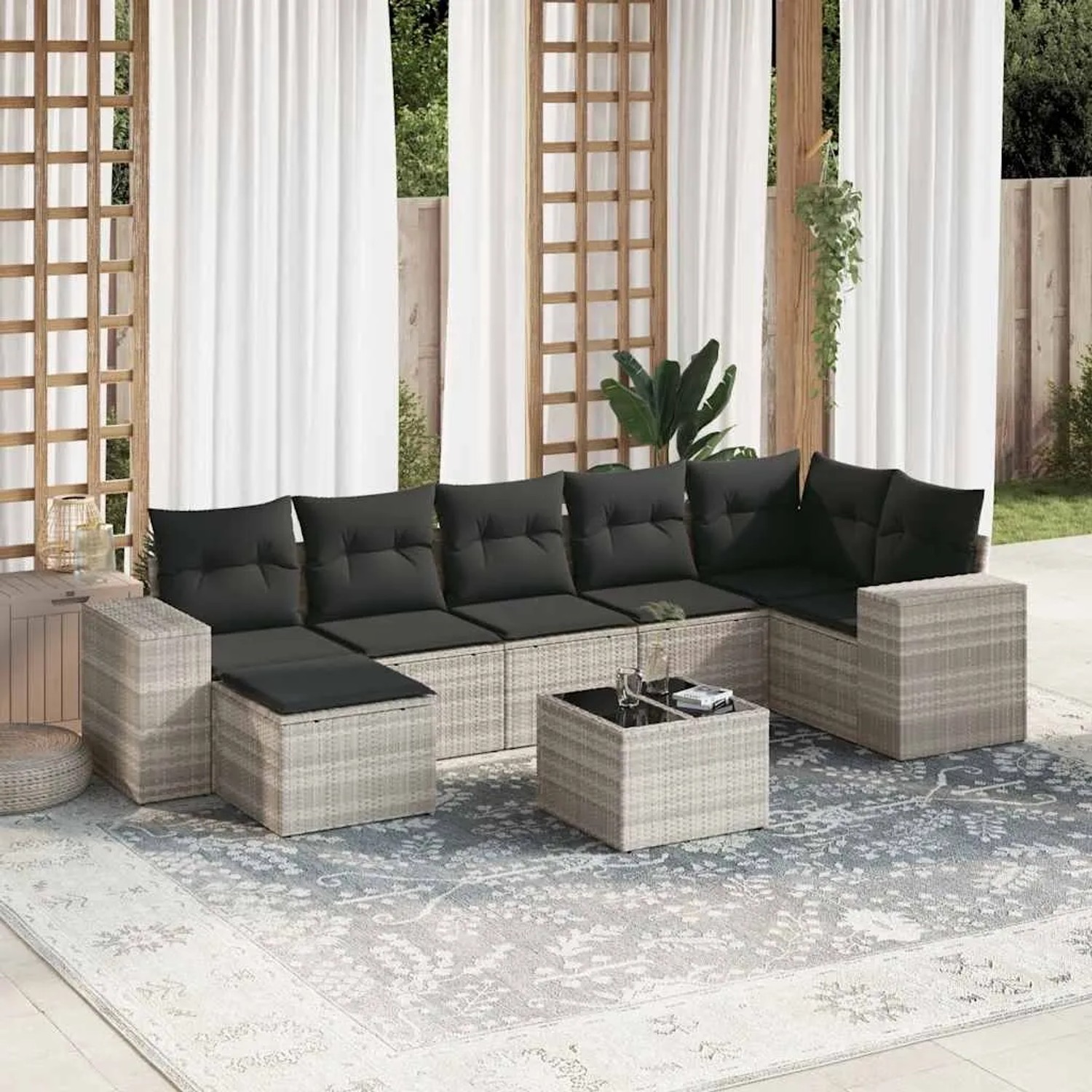 Hellgraue 8-tlg. Garten-Sofagarnitur aus Rattan mit dunklen Kissen und Tisch für Terrasse oder Garten.