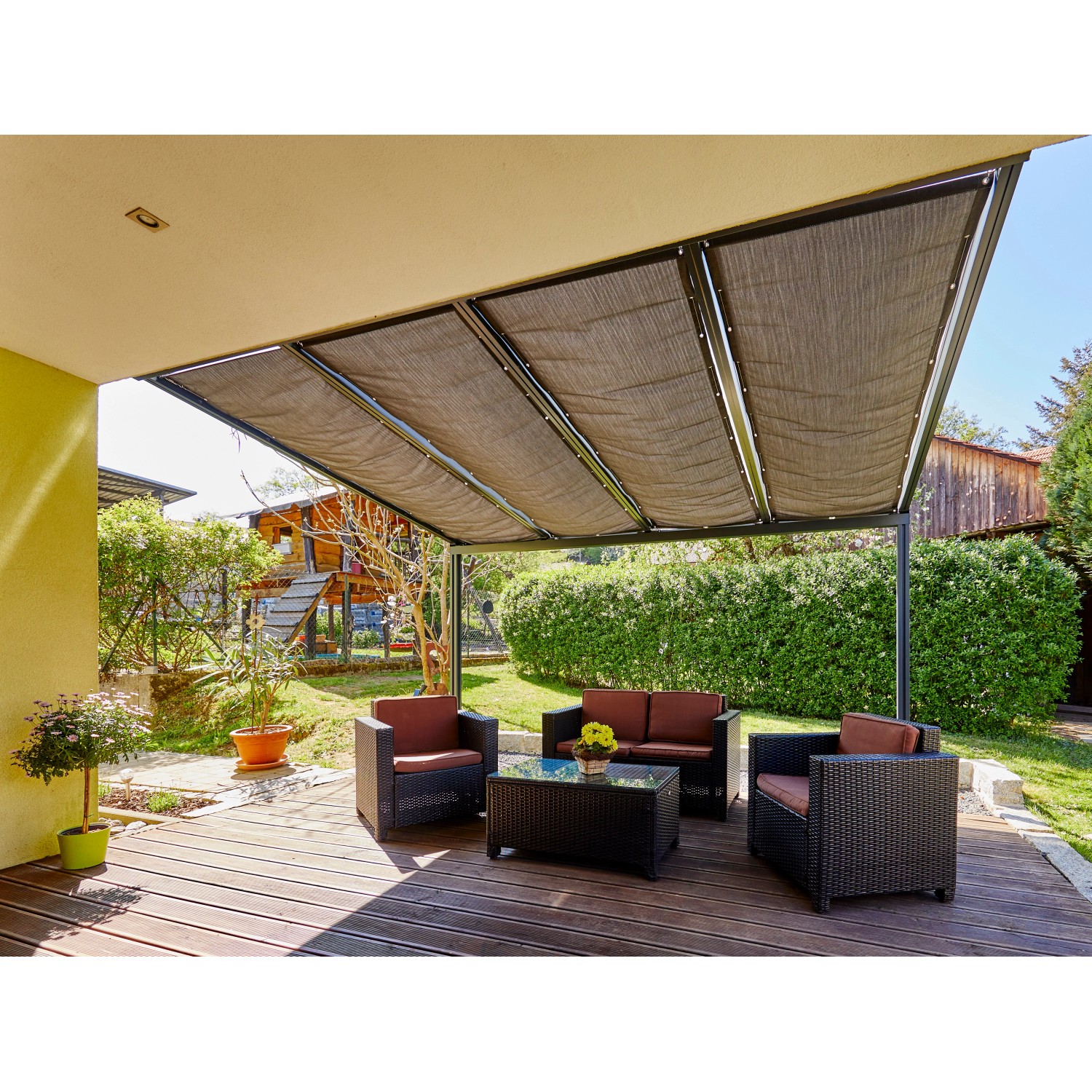 Graphitfarbene Gutta Seilspannmarkise (945 mm x 2900 mm) über einer Terrassenüberdachung mit Sitzgruppe.