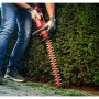 Skil Akku-Heckenschere 0438CA im Einsatz beim Heckenschnitt. Rot, 45 cm Schnittlänge.