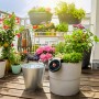 Gardena Aqua Bloom Solar-Bewässerungsset auf Balkon mit blühenden Pflanzen.