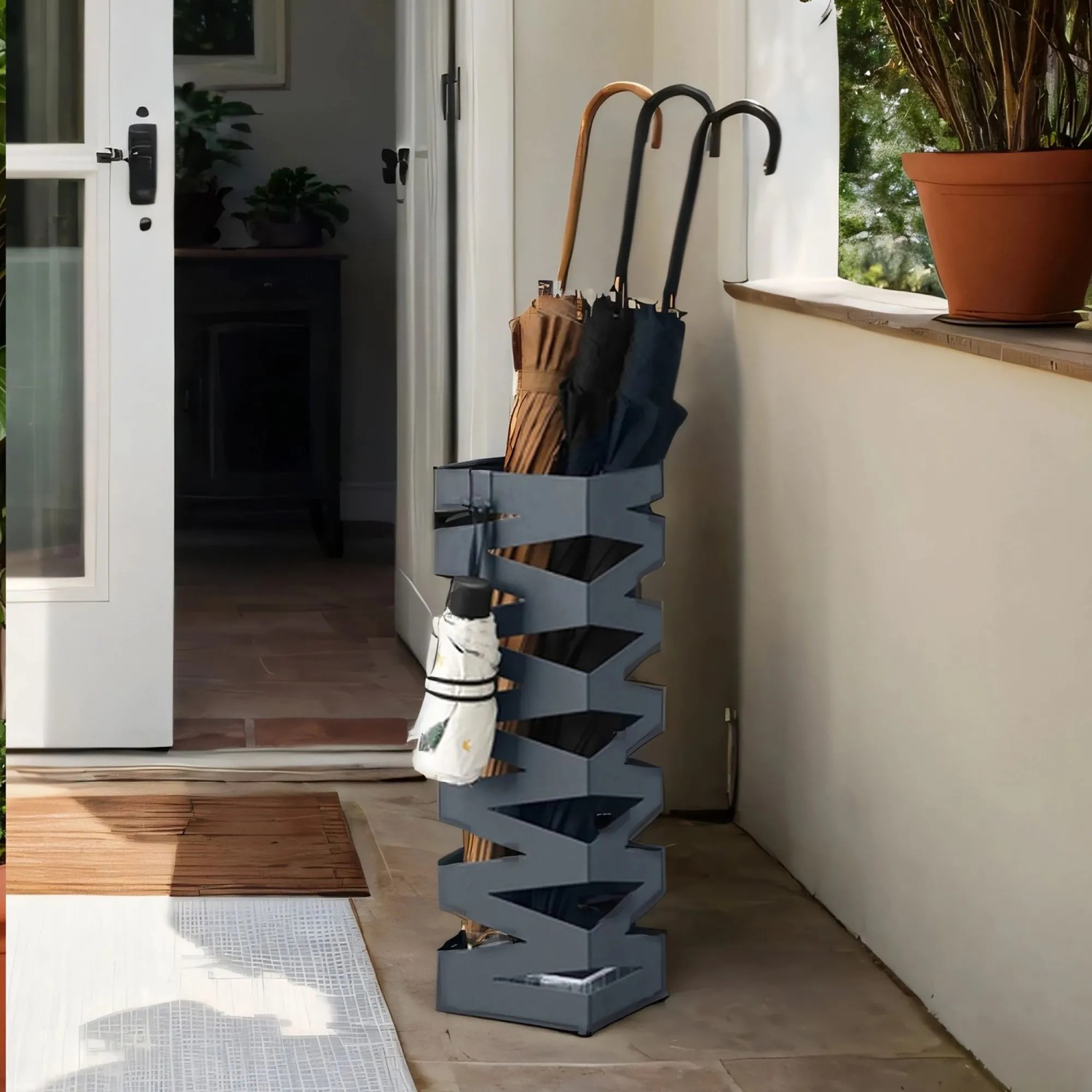 Quadratischer, grauer Songmics Schirmständer aus Metall mit Schirmen.