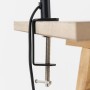Schwarze Metall-Klemmleuchte Dotty an heller Holzplatte befestigt. Zeigt die Klemmfunktion mit Schraube und Kabel.