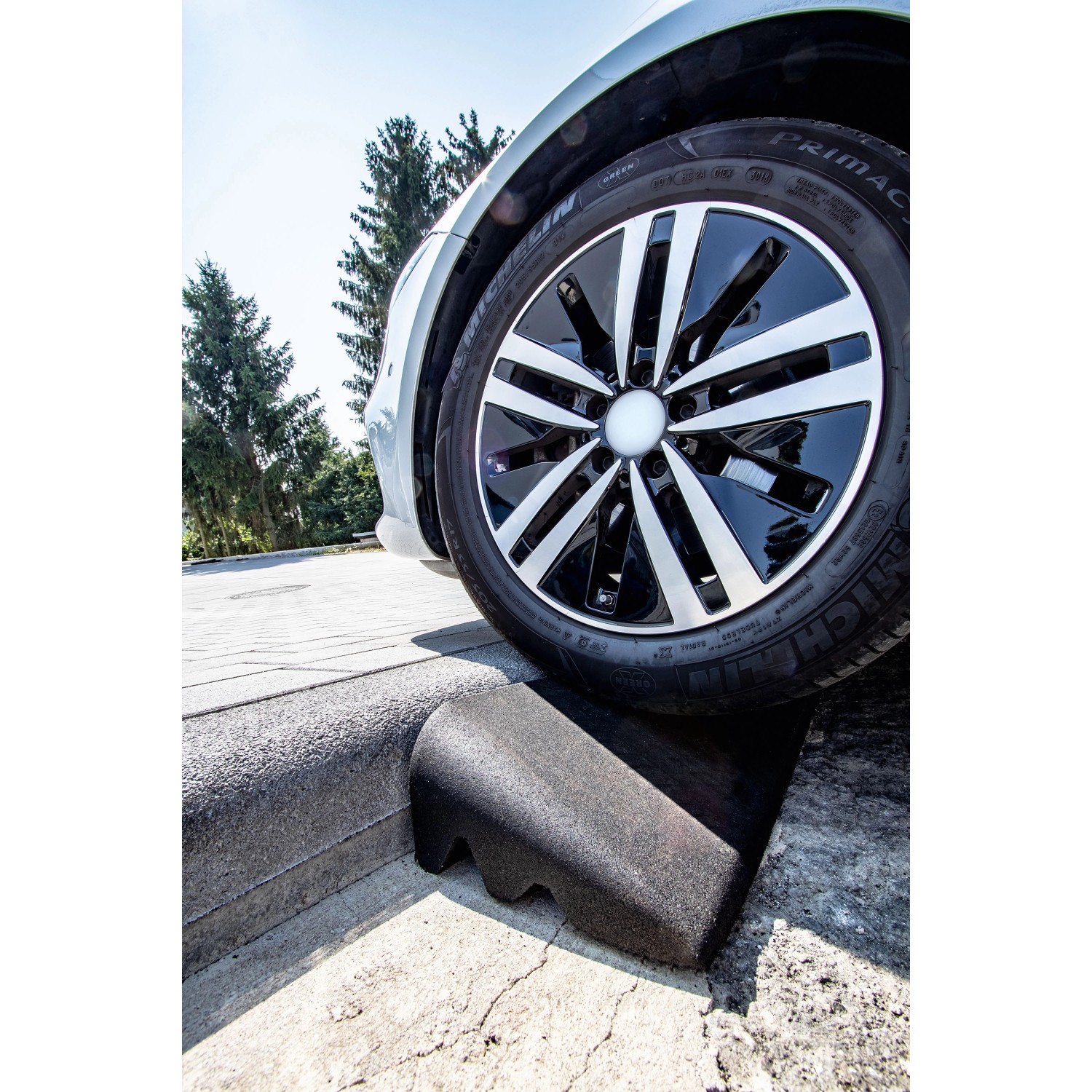 Terrasoft Bordsteinrampe XL im Einsatz: Auto fährt Bordstein hoch. Baugerät für den Kantenschutz.