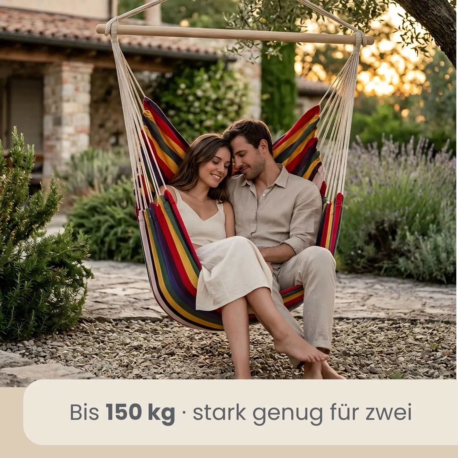 Paar entspannt im bunten AMANKA Hängesessel im Garten. Belastbar bis 150 kg, ideal für zwei Personen.