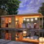 Karibu Holz-Gartenhaus Ängelholm mit Pultdach und überdachter Terrasse am Wasser.