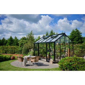 Schwarzes Juliana Gewächshaus Jubii 60 (10,9 m²) im Garten mit Sitzgruppe.
