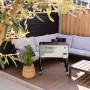 Axi Kühlwagen Retro Edelstahl 76 l auf Terrasse mit Sitzgruppe und Tisch.