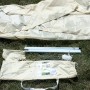 Floracord Camping Dreieckssonnensegel, sandfarben, mit Zubehör wie Heringe, Stangen und Tragetasche.