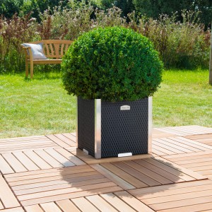 Brauner Polyrattan-Pflanzkübel (38x38 cm) mit Alu-Beschlägen und Bepflanzung im Garten.