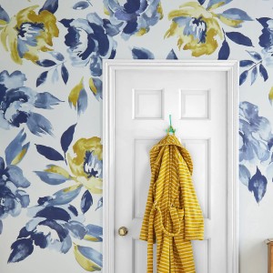 Joules Fototapete Ocean Bloom: Blau-grüne Blumen auf creme-farbenem Grund, neben einer Tür.
