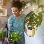 Frau nutzt schwarze Holz-Tafelklammern zum Beschriften von Pflanzen. Ideal für Kräuter, Blumen & Deko.