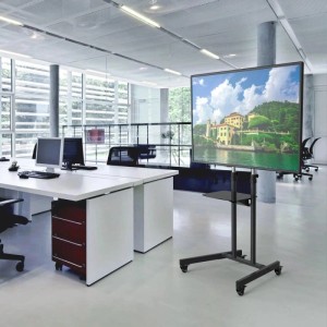 Schwarzer, höhenverstellbarer TV-Ständer mit feststellbaren Rollen und Glasablage im modernen Büro. Mobiler Fernsehständer.