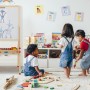 Kinder spielen neben höhenverstellbarer Relaxdays Standtafel aus Holz mit Whiteboard und Kreidetafel im Kinderzimmer.