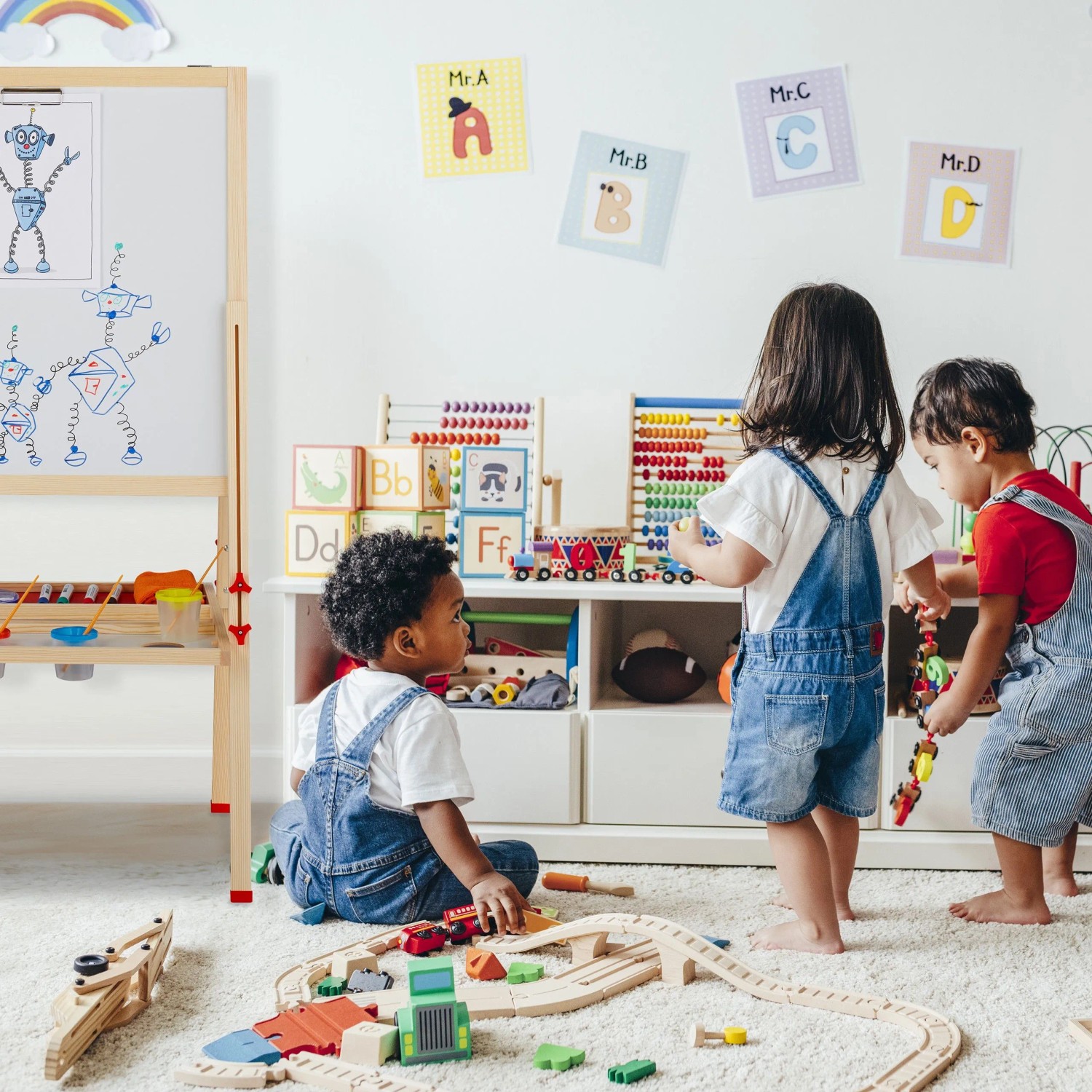 Kinder spielen neben höhenverstellbarer Relaxdays Standtafel aus Holz mit Whiteboard und Kreidetafel im Kinderzimmer.
