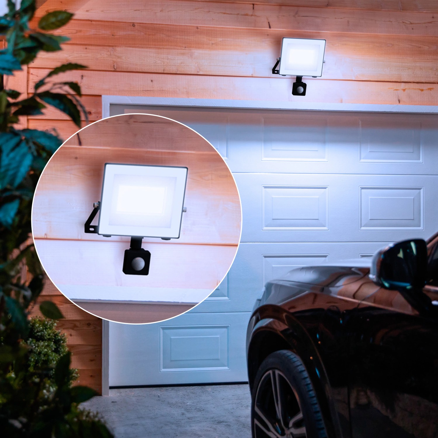 Philips Lois LED-Außenstrahler mit Sensor, anthrazit, an einer Garagenwand montiert.