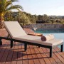 Braune Poly-Rattan Sonnenliege mit cremefarbenem Kissen am Pool auf Holzdeck. Verstellbare Gartenliege für Entspannung.