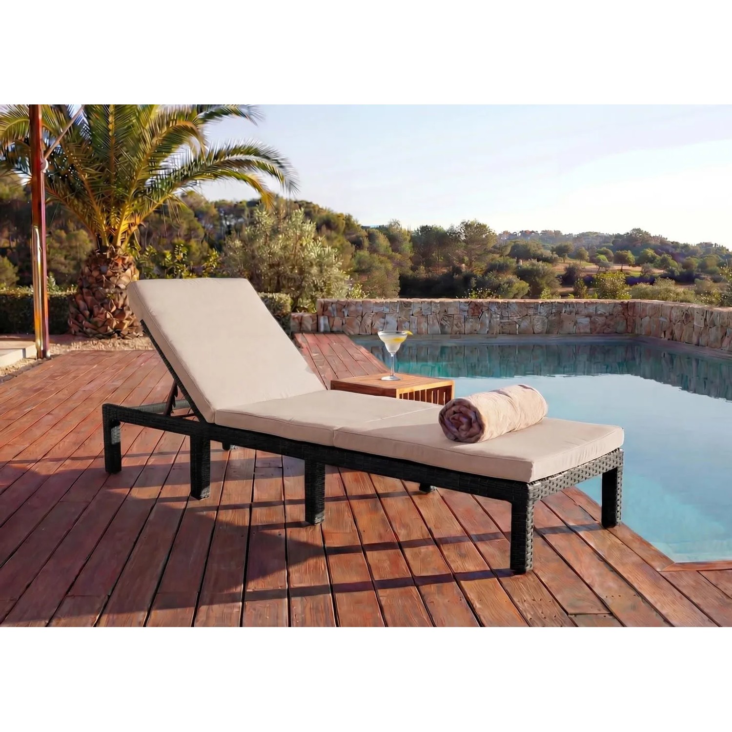 Braune Poly-Rattan Sonnenliege mit cremefarbenem Kissen am Pool auf Holzdeck. Verstellbare Gartenliege für Entspannung.