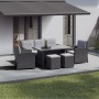 Verlegte graue Klickfliesen aus Naturstein auf einer Terrasse mit Gartenmöbeln und Markise.
