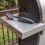 Char-Broil Grillbürste Cool Clean Premium auf einem Grilltisch. Grillutensil mit Schaber und Haken.