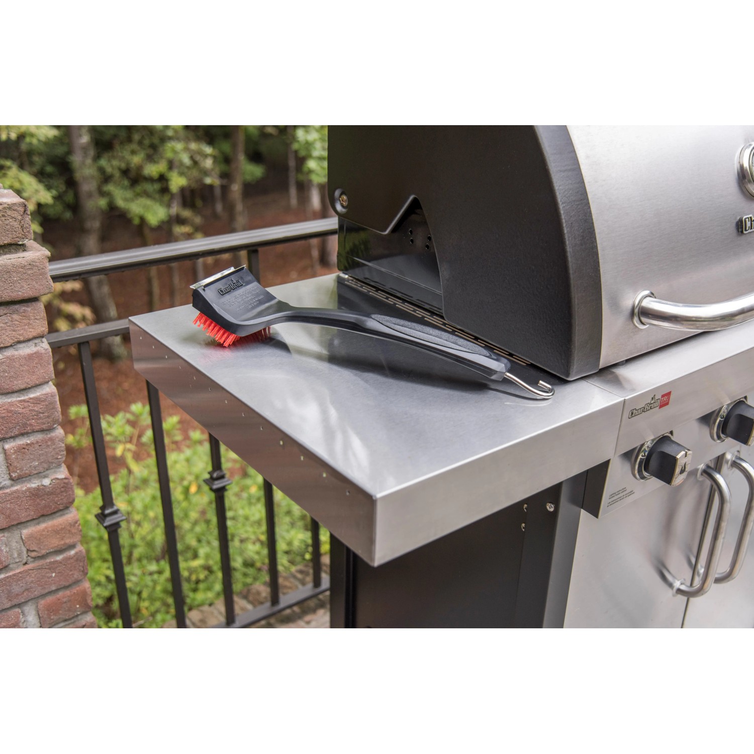 Char-Broil Grillbürste Cool Clean Premium auf einem Grilltisch. Grillutensil mit Schaber und Haken.