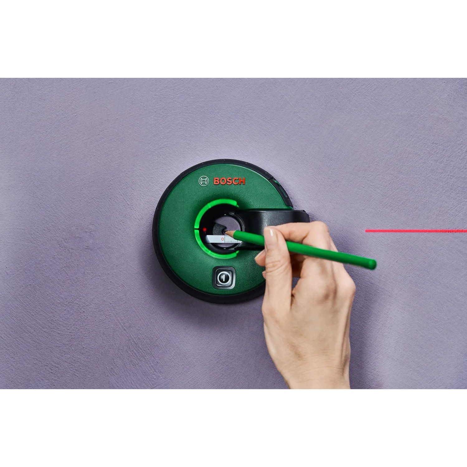 Bosch Atino Linienlaser an Wand mit Laserlinie und Hand mit Stift zum Markieren.