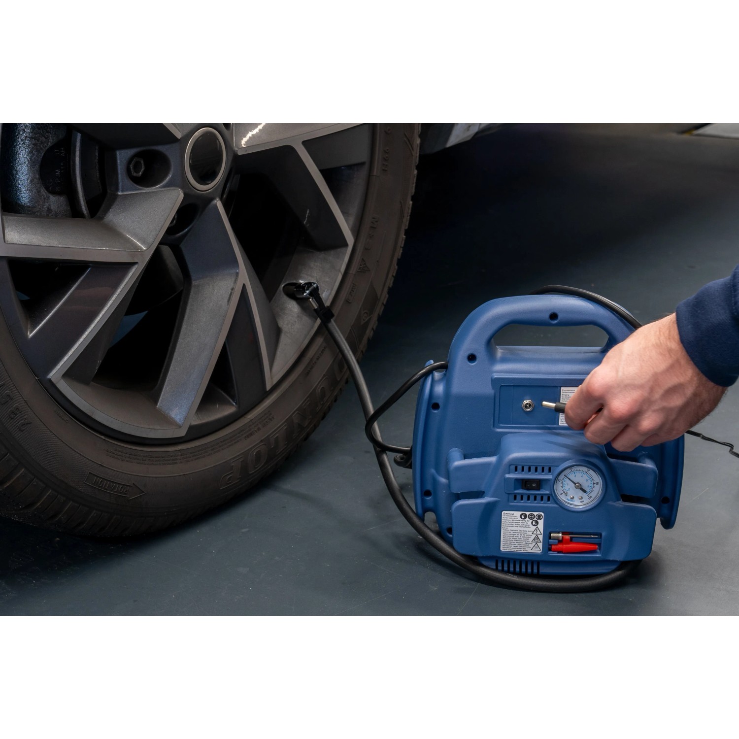 Cartrend Energiestation beim Aufpumpen eines Autoreifens. Mobile Starthilfe mit Kompressor.