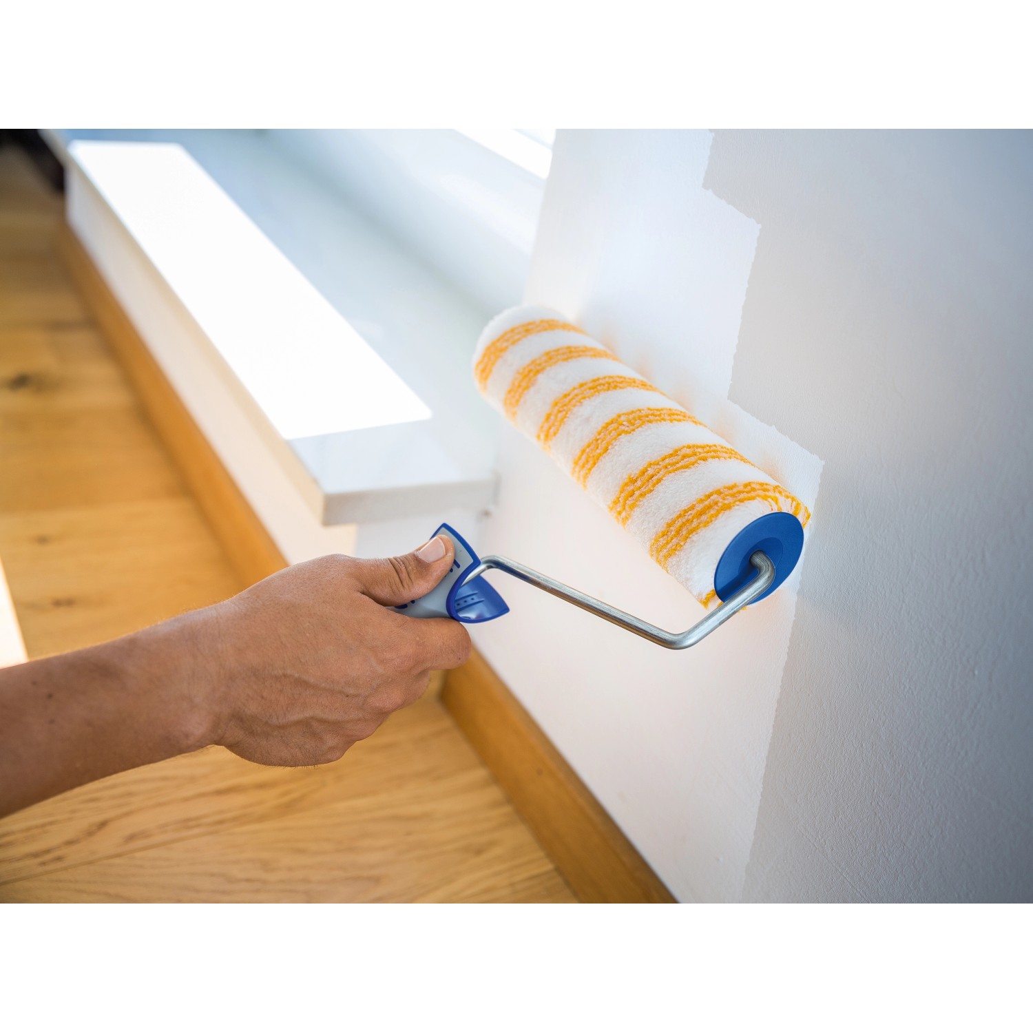 LUX Dispersionswalze 18 cm Glatt beim Streichen einer Wand, gelb-weiß gestreift.