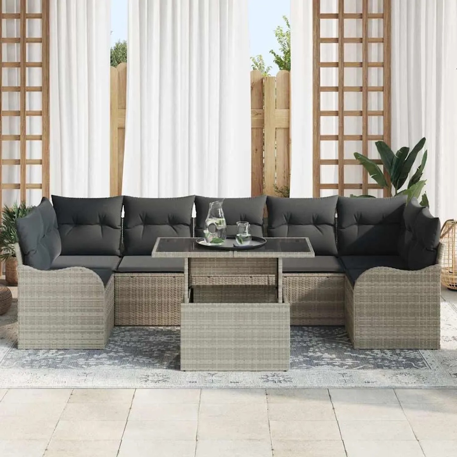 Hellgraues 8-teiliges Gartensofa Set aus Polyrattan mit Tisch und Kissen.