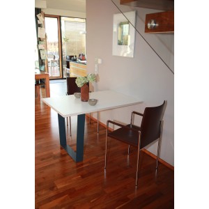 Schwarzes Tischuntergestell in V-Form (700x710mm) unter weißer Tischplatte im Wohnraum.