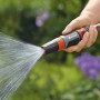 Gardena Reinigungsspritze in Aktion: Hand hält Spritze, Wasserstrahl ist sichtbar.