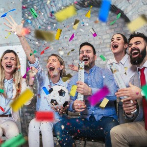 Jubelnde Gruppe feiert mit bunten Konfettikanonen und fallendem Konfetti. Perfekt für Party, Silvester, Hochzeit.