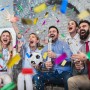 Jubelnde Gruppe feiert mit bunten Konfettikanonen und fallendem Konfetti. Perfekt für Party, Silvester, Hochzeit.