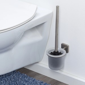 Tiger WC-Garnitur Onu aus gebürstetem Edelstahl mit Glasbehälter neben einer Toilette.