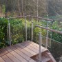 Handlauf aus Sapelli Massivholz (Ø 40mm, 2250mm) auf einer Holzterrasse mit Glasgeländer.