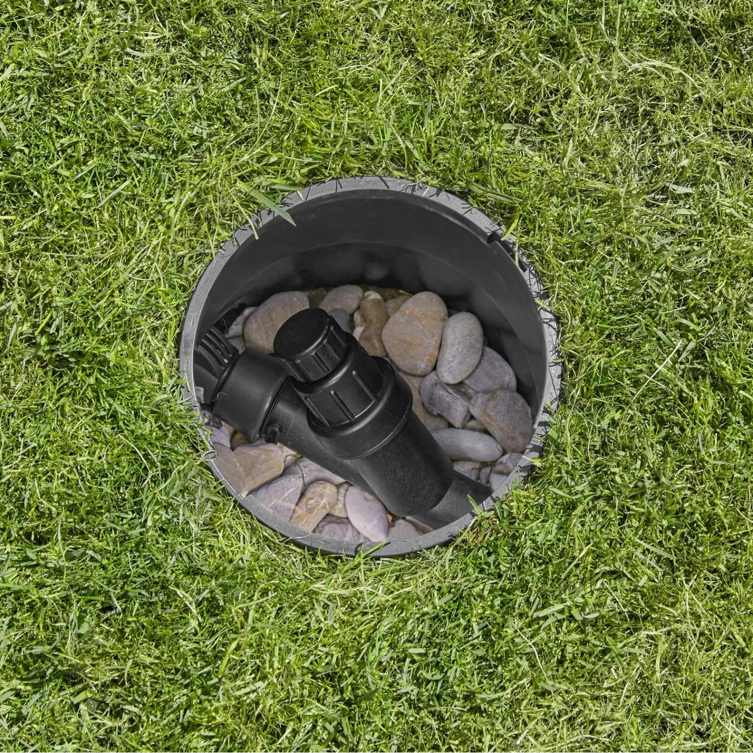 Gardena Druckminderer im Sprinkler-System: gleicht Druck aus, eingebaut in Ventilbox mit Steinen.