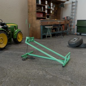 Grüner Juskys Rasentraktorheber mit Handschuhen in Werkstatt-Szene.
