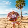 Frau mit Bestway Schwimmring Donut (Ø 107 cm) am Strand.