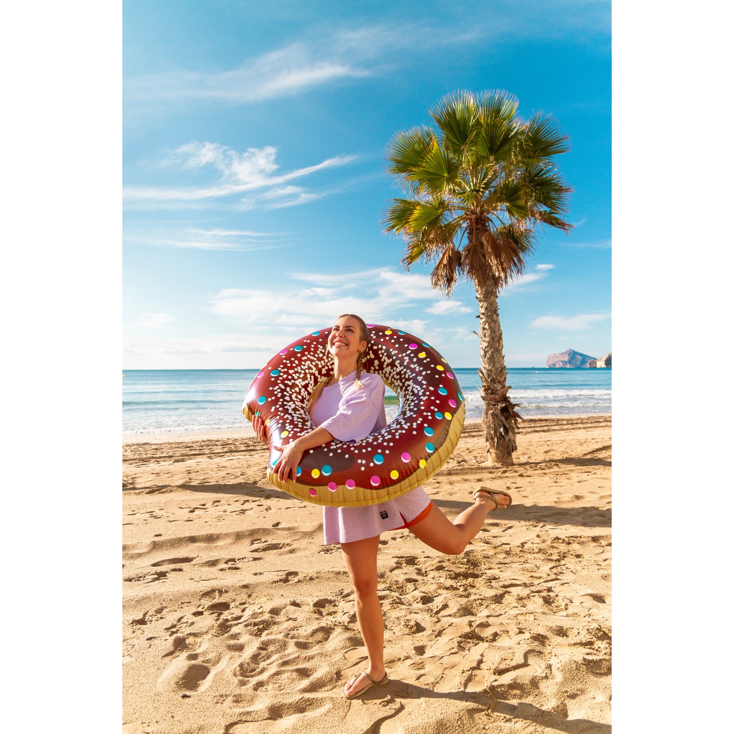 Frau mit Bestway Schwimmring Donut (Ø 107 cm) am Strand.