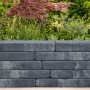 Mauer aus grauen Diephaus Arona Quarzit Mauersteinen (60x20x7 cm) im Garten.
