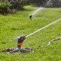 Gardena Premium Rasensprenger mit Schlitten im Einsatz auf Rasenfläche.