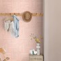 ESTAhome Vliestapete mit rosa 3D-Muster an einer Wand, dazu Holzmöbel und Deko. Ideal für moderne Wohnräume.