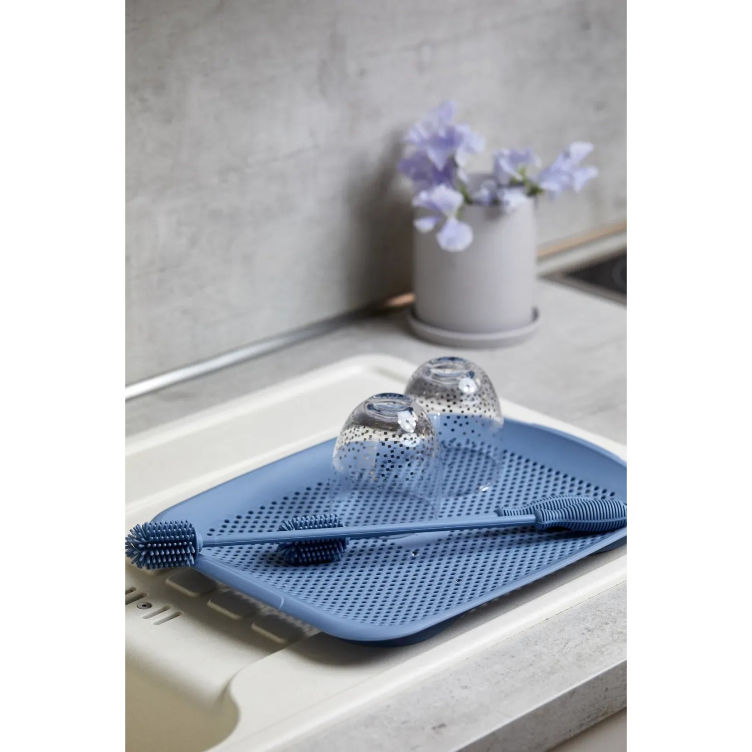 Blaue Wenko Silikon Flaschenbürste (38 cm) auf Abtropfgestell mit Gläsern. Küchenhelfer für Flaschen.