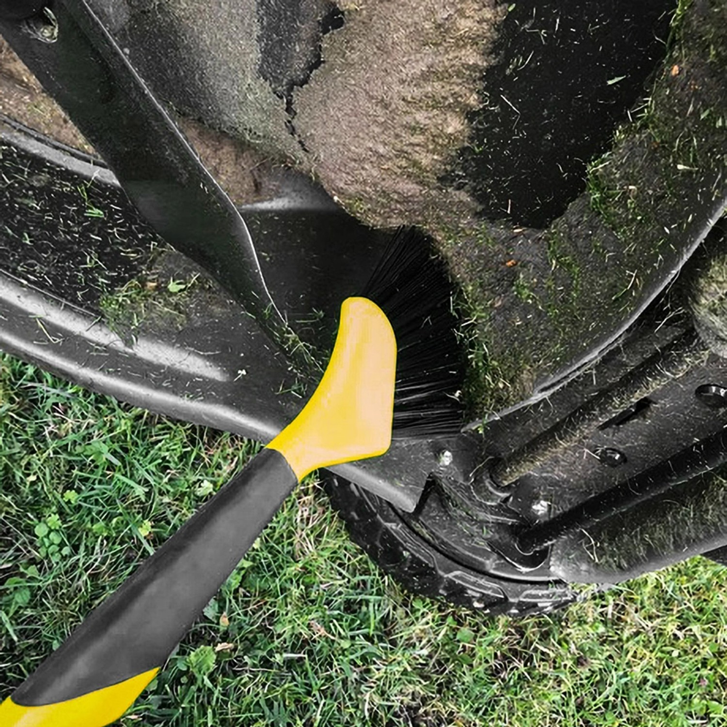 Texas Reinigungswerkzeug Universal im Einsatz am Mähroboter. Bürste entfernt Grasreste.