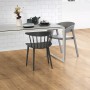 Egger Laminat EL2733 NatureSense Hamilton Eiche im Wohnraum mit Stühlen und Tisch.