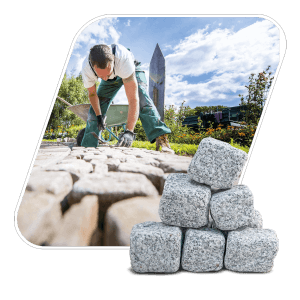 Galamio Granitpflastersteine 8/11 getrommelt, mit Pflasterer im Hintergrund. Ideal für Gartenwege und Plätze.