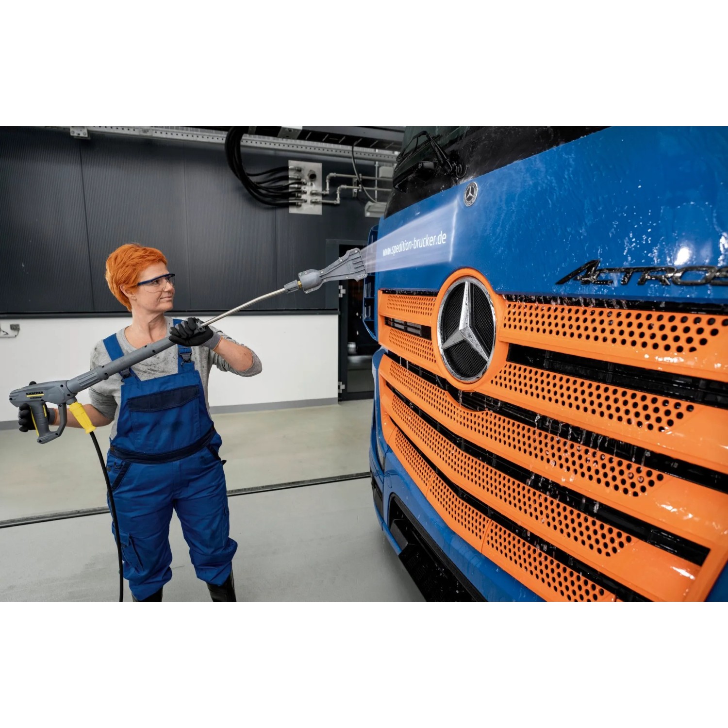 Frau reinigt LKW mit Kärcher eco!Booster Strahlrohr. Flächenreiniger für Hochdruckreiniger.