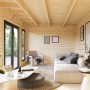 Innenansicht: Hellbraunes Palmako Holz-Gartenhaus mit Pultdach als Wohnraum eingerichtet.