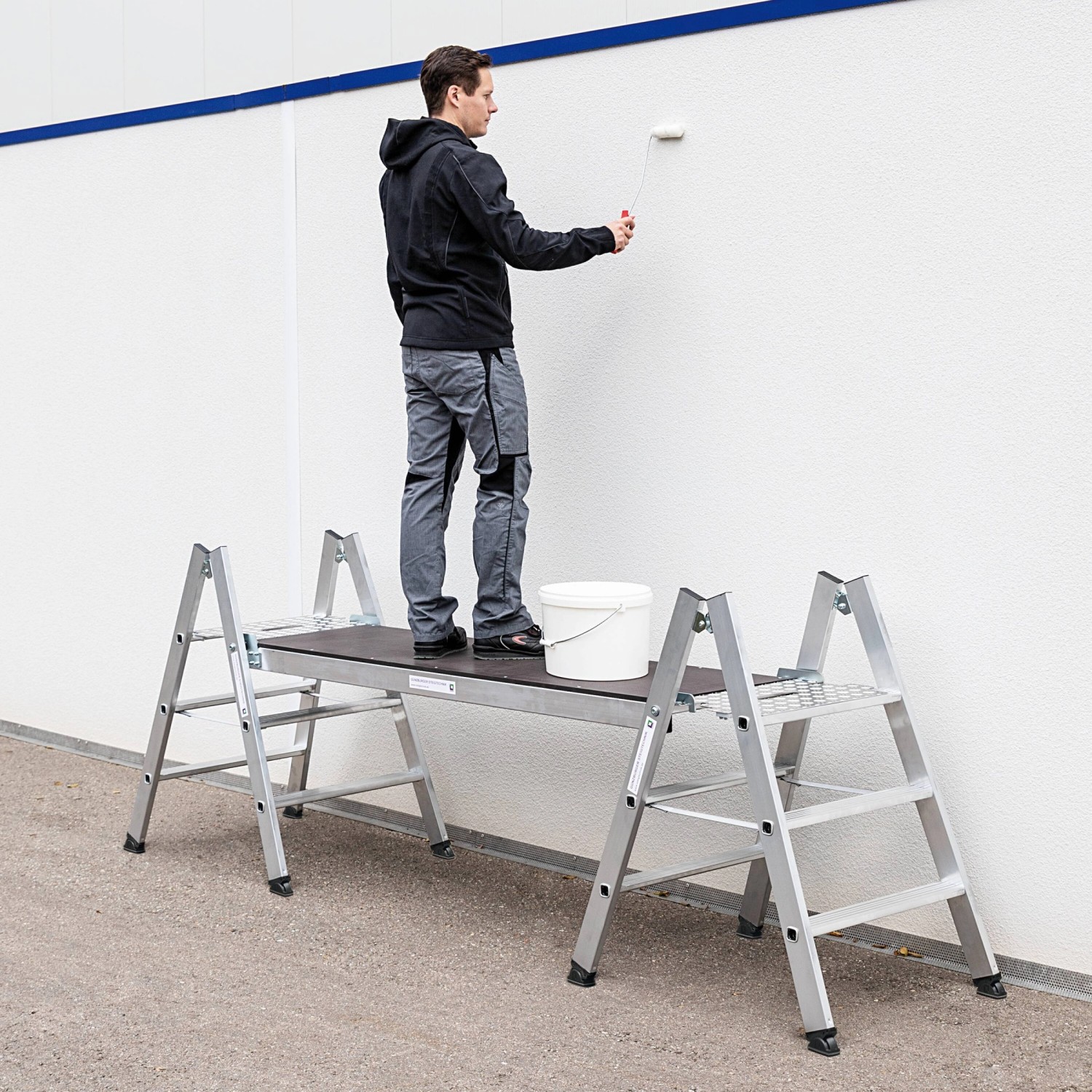 MUNK Klapptritt, beidseitig begehbar, 4 Stufen, Alu natur, mit Maler bei der Arbeit.